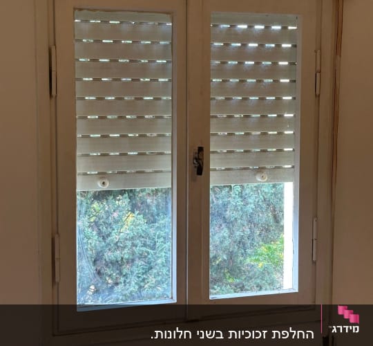 חלון כפול עם זכוכית סדוקה ושבורה בכנף השמאלית